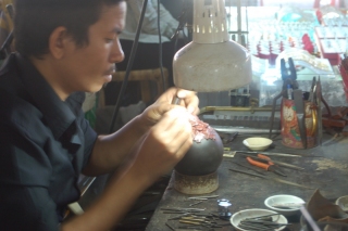 A lapidary works patiently on setting shining gems in bright gold, while I fail patiently at trying to take a shot where his hands don't completely cover the bit of bling